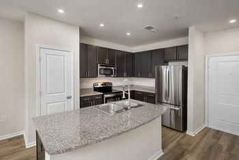 A kitchen with a granite countertop and stainless steel appliances.
